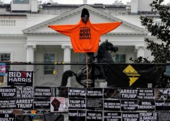 Camisetas con lemas contra Donald Trump desplegadas sobre una barrera de protección alrededor de la Casa Blanca - REUTERS