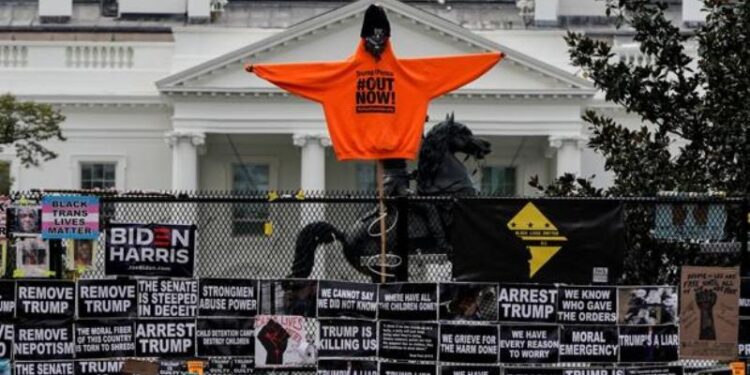 Camisetas con lemas contra Donald Trump desplegadas sobre una barrera de protección alrededor de la Casa Blanca - REUTERS