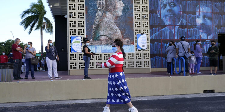 Yanitza Martinez wears red, white, and blue as she arrives to vote outside of the John F. Kennedy Library during the general election, Tuesday, Nov. 3, 2020, in Hialeah, Fla. (AP Photo/Lynne Sladky)