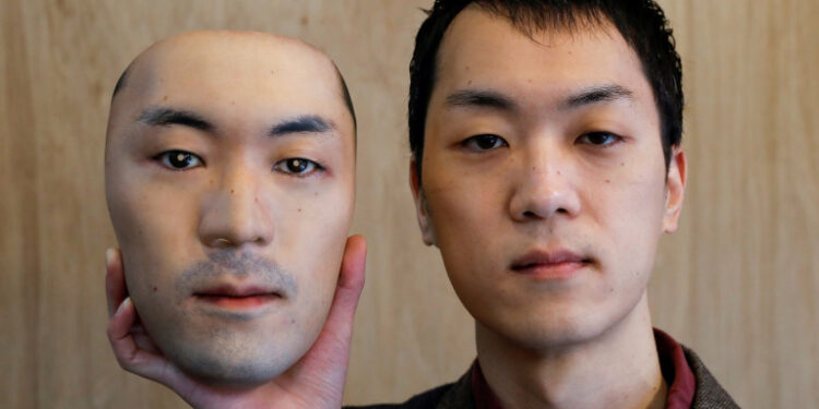 Shuhei Okawara, 30, owner of mask shop Kamenya Omote, holds a super-realistic face mask based on his real face, made by using 3D printing technology, in Tokyo, Japan December 16, 2020. REUTERS/Issei Kato