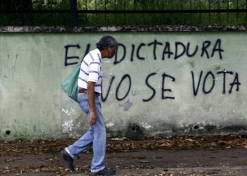 Un hombre pasea junto a un mural contra las elecciones parlamentarias de Venezuela. Zuma Press