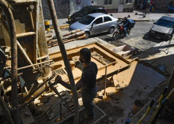 A man works during a water well drilling at the Chacao neighborhood in Caracas on October 31, 2020, amid the new coronavirus pandemic. - The drilling of wells in the Venezuelan capital gained strength during the pandemic, in view of the deficient service of drinking water. (Photo by Federico PARRA / AFP)