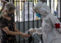 Personal sanitario rocía líquido desinfectante a una mujer. EFE/ Miguel Gutiérrez/Archivo