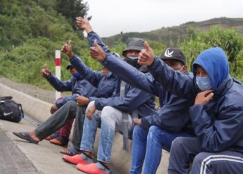 Grupos de migrantes venezolanos descansan junto a una carretera ayer, en la región de Tulcán (Ecuador). El cierre de fronteras por la covid-19 en los países andinos no impide que miles de venezolanos sigan cruzando por trochas de un país en otro movidos por el "virus del hambre", todo un desafío para los Gobiernos que tratan de impedir la propagación del coronavirus. EFE/ Xavier Montalvo