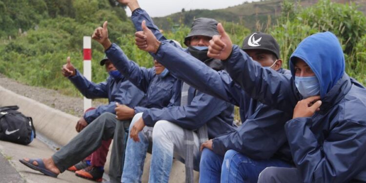 Grupos de migrantes venezolanos descansan junto a una carretera ayer, en la región de Tulcán (Ecuador). El cierre de fronteras por la covid-19 en los países andinos no impide que miles de venezolanos sigan cruzando por trochas de un país en otro movidos por el "virus del hambre", todo un desafío para los Gobiernos que tratan de impedir la propagación del coronavirus. EFE/ Xavier Montalvo