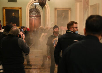 Supporters of US President Donald Trump enter the US Capitol as smoke fills the corridor on January 6, 2021, in Washington, DC. There are no reports of tear gas being used at the Capitol. - Demonstrators breeched security and entered the Capitol as Congress debated the a 2020 presidential election Electoral Vote Certification. (Photo by Saul LOEB / AFP) (Photo by SAUL LOEB/AFP via Getty Images)