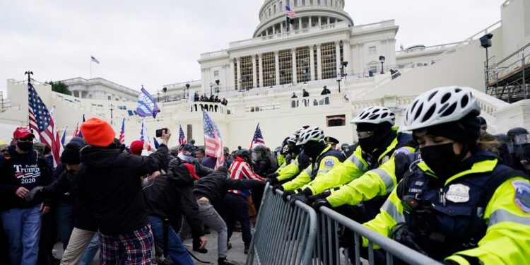 Trump supporters try to break through a police barrier, Wednesday, Jan. 6, 2021, at the Capitol in Washington. As Congress prepares to affirm President-elect Joe Biden's victory, thousands of people have gathered to show their support for President Donald Trump and his claims of election fraud. (AP Photo/John Minchillo)