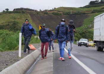 Grupos de migrantes venezolanos caminan por una carretera ayer, en la región de Tulcán (Ecuador). El cierre de fronteras por la covid-19 en los países andinos no impide que miles de venezolanos sigan cruzando por trochas de un país en otro movidos por el "virus del hambre", todo un desafío para los Gobiernos que tratan de impedir la propagación del coronavirus. EFE/ Xavier Montalvo