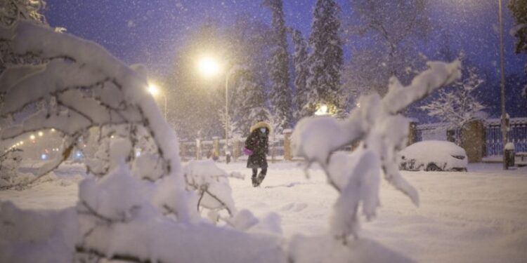 A woman walks amid a heavy snowfall in Madrid on January 9, 2021. - Heavy snow fell across much of Spain, leaving huge areas blanketed in white as Storm Filomena brought wintry weather not seen in decades to the Iberian peninsula. (Photo by Benjamin Cremel / AFP)