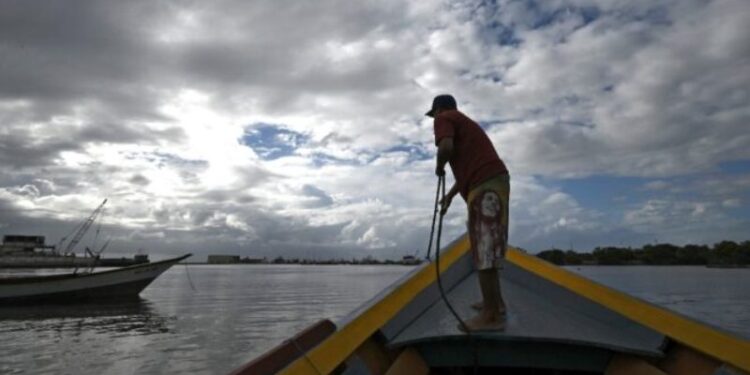 Un pescador se prepara a zarpar para participar en la búsqueda de víctimas de un naufragio en Guiria, en Venezuela, el 18 de diciembre de 2020, tras la muerte de varios migrantes que intentaban cruzar hacia Trinidad y Tobago© AFP YURI CORTEZ