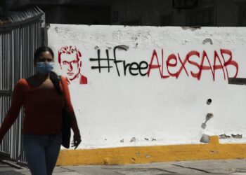 A pedestrian passes in front of “Free Alex Saab” graffiti “ in Caracas, on Feb. 4. Photographer: Carlos Becerra/Bloomberg