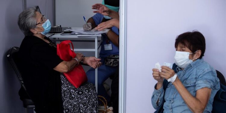 Personas mayores esperan para recibir la primera dosis de la vacuna china Sinovac contra la Covid-19 el 3 de febrero de 2021, en un centro habilitado para la vacunación en masa, en Santiago (Chile). EFE/ Alberto Valdés