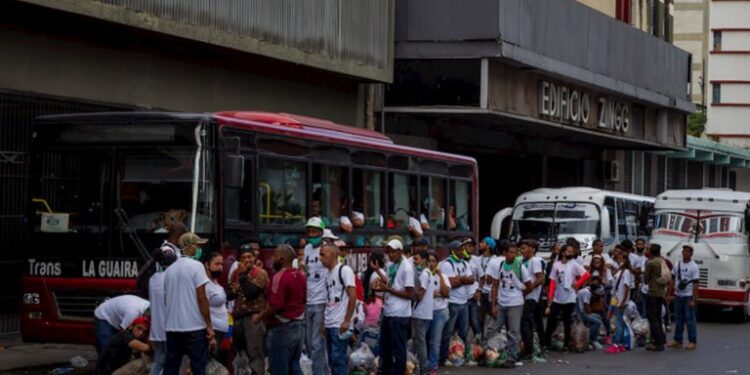 Personas sin guardar el distanciamiento social, ni usando el tapabocas para ´revenir el covid, retirando bolsas de comida como parte de pago luego de asistir a un concierto organizado por el régimen de Maduro.