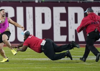 Los agentes de seguridad intentan detener al hombre que invadió el campo en el Super Bowl LV (Foto: AP)