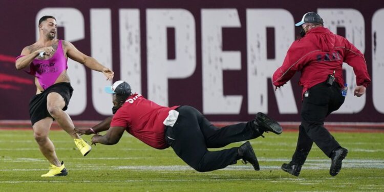 Los agentes de seguridad intentan detener al hombre que invadió el campo en el Super Bowl LV (Foto: AP)