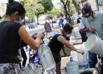 Imagen referencial de personas recolectando agua en una calle, en Caracas, Venezuela. 23 de marzo de 2020. REUTERS. Manaure Quintero