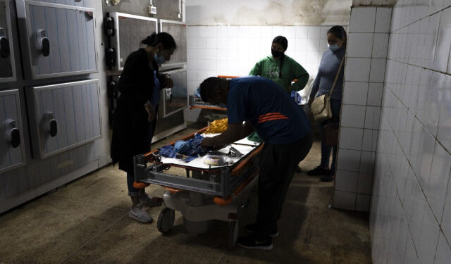 Wendy Dulcey (L) and her husband prepare the body of their one-month-old son who died in the intensive care room of the University Hospital in Caracas on January 10, 2021. - Infant mortality in Venezuela increased 30.12% in 2016, with 11,466 deaths of children aged 0 to 1 year, and maternal mortality soared 65%, according to the latest figures published by the Ministry of Health. (Photo by Yadira PEREZ / AFP)