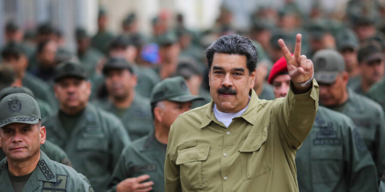 In this handout photo released by the Miraflores Presidential Press Office, Venezuela's President Nicolas Maduro flashes a V for Victory hand gesture after arriving at the Fort Tiuna military base in Caracas, Venezuela, Wednesday, Jan. 30, 2019. Since opposition leader Juan Guaido declared himself interim president last week with the support of the U.S. and other nations, Maduro has appeared almost daily on state TV with his military, projecting an image of invincibility even as international pressure against him builds. (Marcelo Garcia/Miraflores Presidential Press Office via AP)