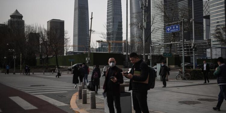 La gente permanece en la calle en medio de la pandemia de coronavirus en Pekín, China. EFE/EPA/WU HONG
