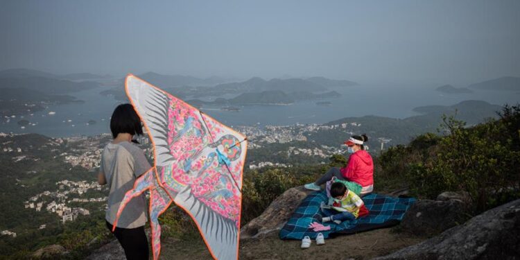 Unos excursionistas vuelan una cometa en un parque rural de Hong Kong, China. Los parques rurales se han convertido en destinos populares para los residentes de Hong Kong, ya que la pandemia de Covid-19 ha puesto fin a los planes de viaje de muchas personas durante más de un año. EFE/ Jerome Favre