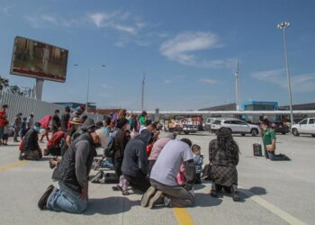 Migrantes rezan hoy en las inmediaciones del cruce fronterizo de El Chaparral, en Tijuana (México). Con una sesión de oración, de la religión católica, un centenar de migrantes centroamericanos pidieron este miércoles en la ciudad de Tijuana la intercesión de Dios para que los "ayude" con la apertura de la frontera de Estados Unidos. Las plegarias de los migrantes se extendieron por poco más de una hora, tiempo en el que elevaron su voz y recordaron que su compañero en su travesía ha sido Dios, en quien expresaron su confianza para que el presidente de Joe Biden cumpla la promesa de abrir las fronteras. EFE/Joebeth Terríquez