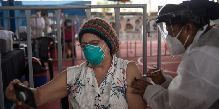 Una mujer recibe una vacuna contra la covid-19 el 10 de marzo de 2021, en el campo polideportivo del barrio Gerona, en Ciudad de Guatemala (Guatemala). EFE/ Esteban Biba/Archivo