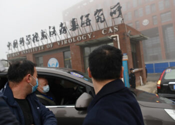 Members of the World Health Organization (WHO) team investigating the origins of the COVID-19 coronavirus arrive by car at the Wuhan Institute of Virology in Wuhan in China's central Hubei province on February 3, 2021. (Photo by HECTOR RETAMAL / AFP)
