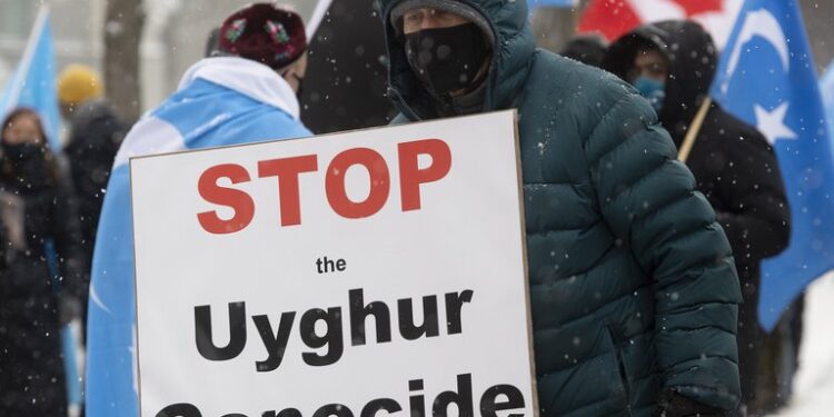 Manifestantes se expresan contra China frente a los edificios del Parlamento en Ottawa, Ontario, por el genocidio de la etnia musulmana uigur. (Adrian Wyld / The Canadian Press vía AP)