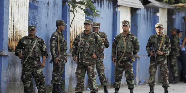 Nicaraguan soldiers stand guard at the border between Costa Rica and Nicaragua, as seen from Penas Blancas, Costa Rica, November 25, 2015. Thousands of Cubans remain stuck on the Costa Rican side of the border with Nicaragua after Managua refused at a regional summit on Tuesday to open its doors to a wave of migrants heading for the United States. Fearing the recent rapprochement between Havana and Washington could end preferential U.S. policies for Cuban migrants, thousands of people from the Communist-ruled island have been crossing into South America and traveling through Central America hoping to reach U.S. soil. REUTERS/Juan Carlos Ulate