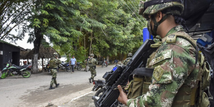 Colombian soldiers patrol near the Arauca river in Arauquita municipality, Arauca department, Colombia on March 25 , 2021. - More than 3,000 people fled to Colombia to escape fighting that broke out over the weekend in Venezuela between its military and suspected FARC dissidents, officials in Bogota said Wednesday. Venezuela's military clashed with the group near the border with Colombia on Sunday, resulting in the death of two military personnel and the capture of 32 Colombian "insurgents," according to Venezuela's Armed Forces. (Photo by Daniel Fernándo MARTINEZ CERVERA / AFP)