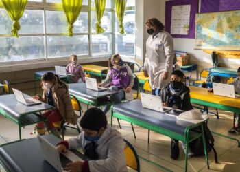 Students wearing protective face masks as a measure to curb the spread of the new coronavirus, attend class in a public school in Montevideo, Uruguay, Monday, June 15, 2020. Life is slowly returning to normal in Uruguay, while other countries in Latin America are still fighting the spread of the new of corona virus.  (AP Photo/Matilde Campodonico)
