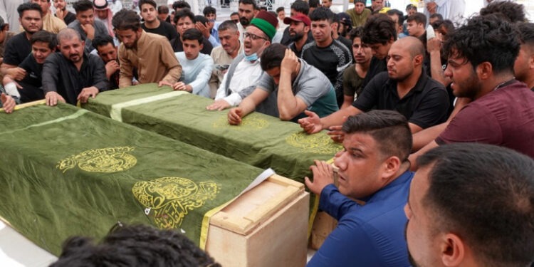 Iraqis mourn relatives killed during a fire in a hospital in the capital, during a funeral procession in the holy shrine city of Najaf, on April 25, 2021. - The fire which erupted  pre-dawn at the Ibn Al-Khatib Hospital in Baghdad, a medical facility reserved for the most severe COVID-19 cases, killed 82 people, sparking angry calls for officials to be sacked in a country with long-dilapidated health infrastructure. (Photo by Ali NAJAFI / AFP)