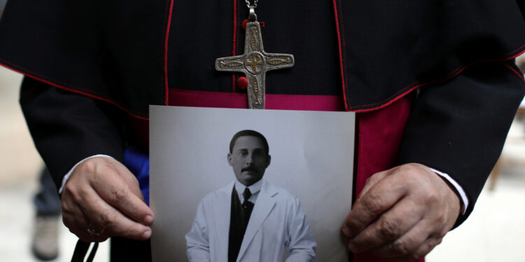 A bishop holds a photo of Jose Gregorio Hernandez, as the Vatican on Friday announced his beatification, after a mass in Caracas, Venezuela, June 19, 2020. REUTERS/Manaure Quintero