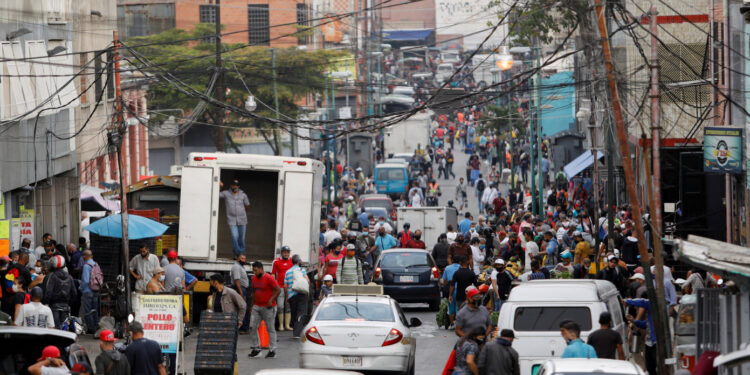 People walk on a busy commercial street amid a spike in infections of the coronavirus disease (COVID-19) that has led the government to extend lockdown measures, in Caracas, Venezuela April 6, 2021.  REUTERS/Leonardo Fernandez Viloria