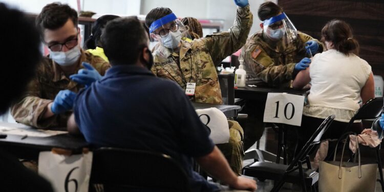 U.S. Department of Defense members administer vaccines to people at Mercedes-Benz Stadium on Thursday, March 25, 2021, in Atlanta. Gov. Brian Kemp said all Georgians 16 and older will be eligible to receive the COVID-19 vaccine. (AP Photo/Brynn Anderson)
