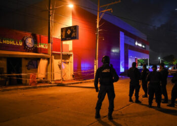Police officers stand guard outside Caballo Blanco bar (White Horse bar) where 25 people were killed by a fire in Coatzacoalcos, Veracruz State, Mexico, on August 28, 2019. - At least 25 people were killed and 13 badly wounded in a fire which broke out Tuesday night at the bar as is being investigated as an attack, authorities said Wednesday. The state of Veracruz is a flashpoint in the bloody turf wars between Mexico's rival drug cartels. (Photo by VICTORIA RAZO / AFP)