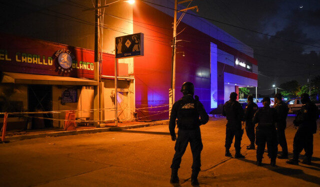 Police officers stand guard outside Caballo Blanco bar (White Horse bar) where 25 people were killed by a fire in Coatzacoalcos, Veracruz State, Mexico, on August 28, 2019. - At least 25 people were killed and 13 badly wounded in a fire which broke out Tuesday night at the bar as is being investigated as an attack, authorities said Wednesday. The state of Veracruz is a flashpoint in the bloody turf wars between Mexico's rival drug cartels. (Photo by VICTORIA RAZO / AFP)