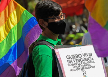 (FILES) In this file photo taken on February 11, 2021 a member of the Venezuelan LGBTI (lesbian, gay, bi-sexual, transsexual and intersex) community takes part in a demonstration demanding marriage equality while holding a signal that reads "I want to live without shame", in front of the National Assembly building in Caracas. - LGBTI organizations in Venezuela, which is behind in the line of Latin American countries in terms of rights of the LGBTI community, are pushing for the new Parliament to discuss an equal marriage law in 2021. (Photo by Federico PARRA / AFP)