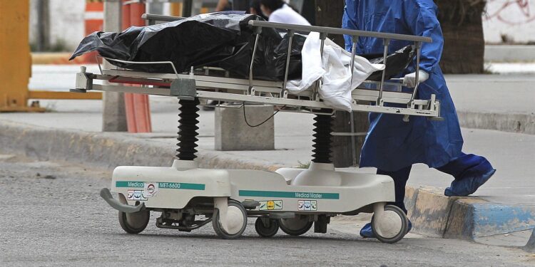Un enfermero traslada el cuerpo de una víctima de Covid-19, hoy a la morgue del Hospital General de Ciudad Juárez estado de Chihuahua (México). EFE/Luis Torres