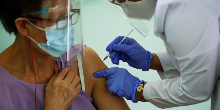 Una mujer recibe la primera dosis de la vacuna Pfizer contra la covid-19 hoy, en la escuela Victoria D'Spinaym, en La Chorrera (Panamá). EFE/ Bienvenido Velasco