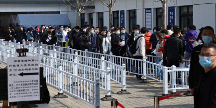 People line up to be vaccinated against the Covid-19 coronavirus, at a vaccination center next to a residential compound in Beijing on April 8, 2021. (Photo by LEO RAMIREZ / AFP)