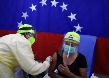 A health worker administers a dose of the Sputnik V vaccine against COVID-19 to a staff member of the Perez de Leon Hospital in Petare neighbourhood, in eastern Caracas, on February 19, 2021, amid the novel coronavirus pandemic. (Photo by Federico PARRA / AFP)