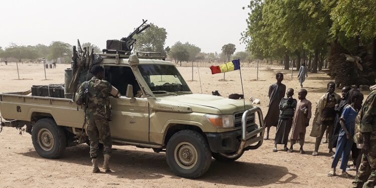 Soldiers of the Chad Army stand next to a Land Cruiser, while bystanders look on, before buing sheep at the Koundoul market, 25 km from N'Djamena, on January 3, 2020, upon their return  after a months-long mission fighting Boko Haram in neighbouring Nigeria. - Chad has ended a months-long mission fighting Boko Haram in neighbouring Nigeria and withdrawn its 1,200-strong force across their common border, an army spokesman told AFP on January 4, 2020. (Photo by - / AFP)
