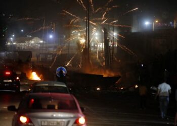 Palestinian protesters throw fireworks at Israeli soldiers during an anti-Israel demonstration over tensions in Jerusalem, at the Qalandiya checkpoint between Ramallah and Jerusalem, in the occupied West Bank, May 11, 2021. - Israel launched deadly air strikes on Gaza on May 10 in response to a barrage of rockets fired by Hamas and other Palestinian militants, amid spiralling violence sparked by unrest at Jerusalem's Al-Aqsa Mosque compound. (Photo by ABBAS MOMANI / AFP)