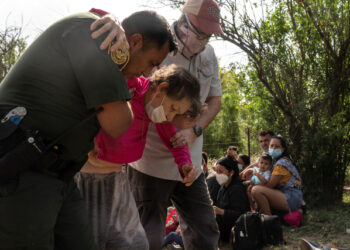 An U.S. Border Patrol agent assists an elderly asylum-seeking migrant woman from Venezuela after the woman crossed the Rio Grande river into the United States from Mexico in Del Rio, Texas, U.S., May 26, 2021. REUTERS/Go Nakamura