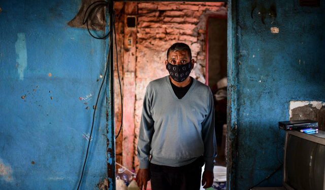 Covid-19 survivor Raul Almiron poses for a picture at his house in Florencio Varela, Buenos Aires province, Argentina, on April 13, 2021. - After beating Covid and spending six months in intensive care, Raul Almiron struggles to go back to his normal life, taking care of his children and returning to work. (Photo by RONALDO SCHEMIDT / AFP)