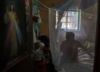 A woman rests wrapped in a mosquito net to protect herself from mosquitos which can transmit malaria at her house in Barcelona, Anzoategui State, Venezuela, on March 16, 2021. - In Venezuela there are people who had malaria up to 20 times. The proliferation, with epicentre in the southern mining region, is a paradox in a country which became the first to eradicate the illness caused by the Plasmodium parasite in 1961. (Photo by Pedro Rances Mattey / AFP)