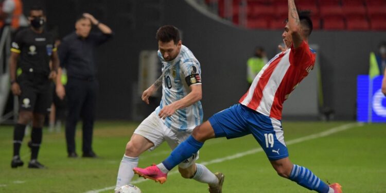 Argentina's Lionel Messi (L) and Paraguay's Santiago Arzamendia vie for the ball during their Conmebol Copa America 2021 football tournament group phase match at the Mane Garrincha Stadium in Brasilia on June 21, 2021. (Photo by NELSON ALMEIDA / AFP)
