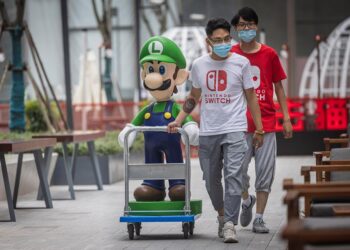Dos hombres conducen una figura del popular Luigi, el personaje del juego de Nintendo Mario Bros juego en el centro comercial CHJ Incity en Shanghai, China. EFE/EPA/Alex Plavevski
