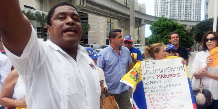 CORRECTION - Jose Colina (L), former National Guard lieutenant and leader of the Organization of Persecuted Venezuelans Living in Exile (VEPPEX), speaks to activist protesting investment company Goldman Sachs outside one of their offices in Miami on June 1, 2017.
Goldman Sachs confirmed on May 30 it purchased bonds from the Venezuelan government. The bonds reportedly had an original value of $2.8 billion, but Goldman Sachs paid $865 million.   / AFP PHOTO / Leila MACOR / The erroneous mentions appearing in the metadata of this photo by Leila MACOR has been modified in AFP systems in the following manner: [Jose Colina (L), former National Guard lieutenant] instead of [Jose Colina (L), former army lieutenant ] AND [original value of $2.8 billion] instead of [original value of $28 billion]. Please immediately remove the erroneous mentions from all your online services and delete them from your servers. If you have been authorized by AFP to distribute them to third parties, please ensure that the same actions are carried out by them. Failure to promptly comply with these instructions will entail liability on your part for any continued or post notification usage. Therefore we thank you very much for all your attention and prompt action. We are sorry for the inconvenience this notification may cause and remain at your disposal for any further information you may require.        (Photo credit should read LEILA MACOR/AFP/Getty Images)